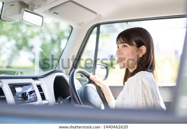 Smiling young woman riding a\
car