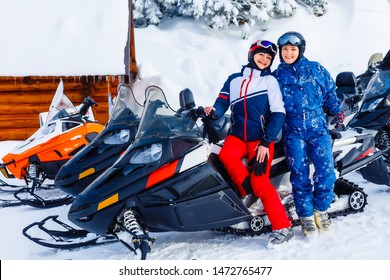 Smiling Young Woman Riding A Snowmobile