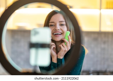 Smiling young woman showing tips on hairstying with curlers