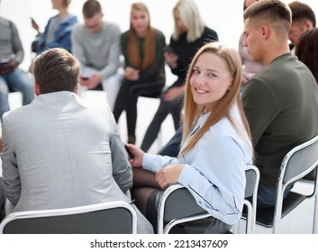 Smiling Young Woman Sitting In A Circle Of Colleagues