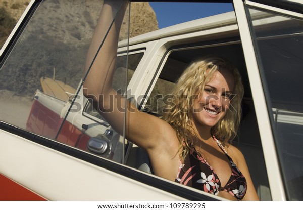 Smiling young
woman sitting in front seat of a
car