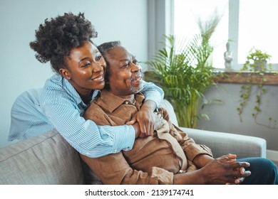Smiling young woman sitting on sofa with happy older retired 70s father, enjoying pleasant conversation together in living room, mature parents and grown children communication. - Shutterstock ID 2139174741