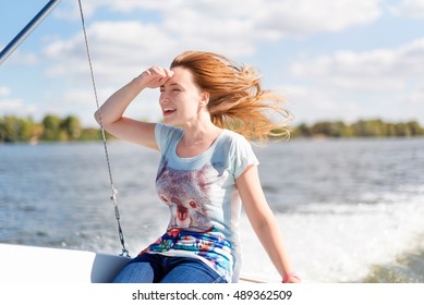 Smiling Young Woman Sitting On Sailboat, Enjoying Mild Sunlight, Sea Or River Cruise, Summer Vacation And Travel Concept