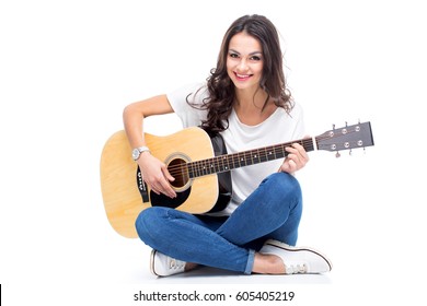 Smiling Young Woman Sitting And Playing Guitar Isolated On White