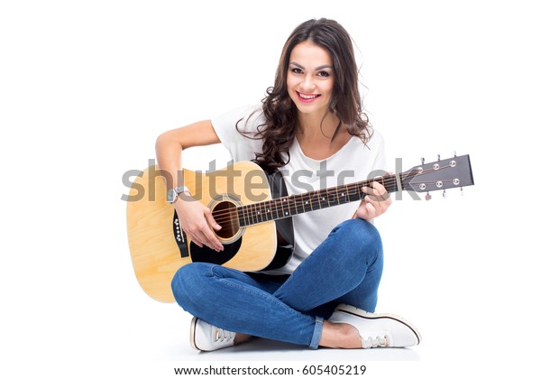 白い背景に座ってギターを弾く にこやかな若い女性 の写真素材 今すぐ編集