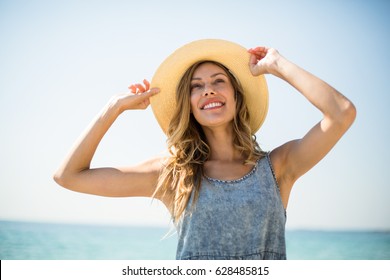 Smiling Young Woman Standing Against Sky On Sunny Day