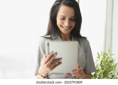 Smiling Young Woman In Suit Holding Digital Tablet