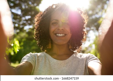 Smiling Young Woman Taking A Selfie While Enjoying A Sunny Summer Afternoon Outside In A Park