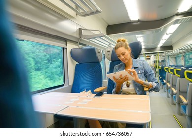 Smiling Young Woman In Train Connected On Tablet