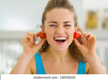 Smiling Young Woman Using Cherry Tomato As Earrings