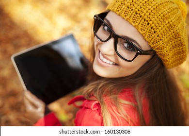 Smiling young woman using digital tablet  - Powered by Shutterstock