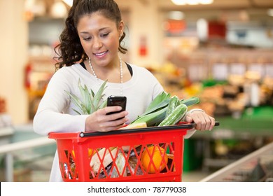 Smiling Young Woman Using Mobile Phone While Shopping In Shopping Store