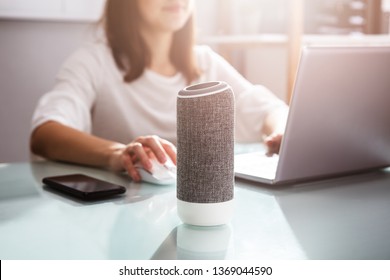 Smiling Young Woman Using Voice Assistant In Office