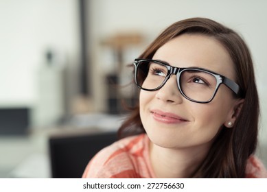 Smiling Young Woman Wearing Eyeglasses with Black Frames and Looking Up as if Daydreaming or Thinking of Something Happy