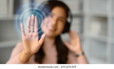 Smiling young woman wearing headphone, pressing button on virtual screen. Future technology, innovation and cyberspace - Shutterstock ID 2311251559