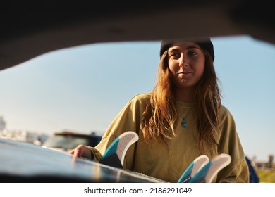 Smiling Young Women Packing Car For Adventure Road Trip At The Beach With Surfboard, Kite Surfing Sunny