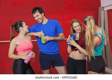 Smiling Zumba Dancers Holding Water Bottles In Gym