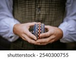 Smiltene, Latvia - October 27, 2024 - A person holds a rolled-up, intricately woven, traditional Latvian belt with blue, beige, and red patterns, representing cultural craftsmanship and heritage.