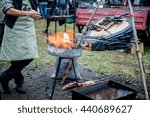 smith warms iron. Master blacksmith heats steel part in the fire. Smith blows the coals and warm metal. Bellows.