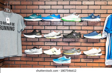 Smithtown, New York, USA - 28 August 2020: The Wall Of A Running Shoe Specialty Store Has Different Brands Of Shoes Displayed On The Wall Next To Some T-shirts.