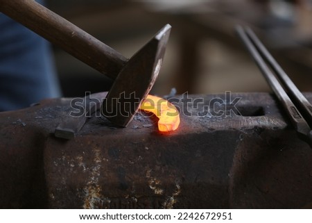  Smithy forging for hardening and heating iron. Blacksmith working at smithy workshop. Smith made an old fashioned  horse shoe 