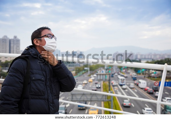 Smog in\
the city.men in medical mask with sore\
throat
