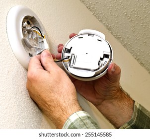 Smoke Alarm Being Repaired On Wall / Time To Check Your Smoke Alarms