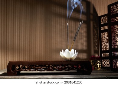 Smoke from burning incense sticks standing on lotus incense holder - Shutterstock ID 2081841280