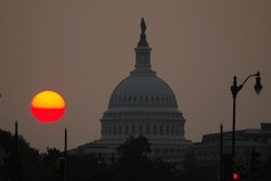 Smoke From Canadian Wildfires Shrouds The Sun As It Sets Behind The U.S. Capitol On July 18, 2023.