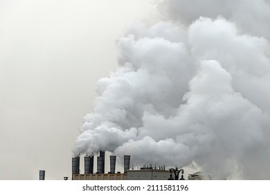 Smoke from chimneys of heating plant. Air pollution. Factory pipes with smoke, frosty weather, sunrise. Ecology problem. - Powered by Shutterstock