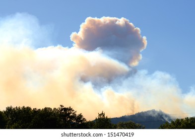 Smoke column rises from the Douglas Complex forest fires near Glendale Oregon in steep rugged terrain of the southern coastal range mountains