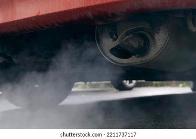 Smoke Is Coming From The Exhaust Pipe Of An Old Car. Close-up. The Concept Of Ecology And Transport.