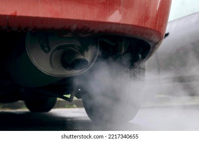 Smoke Is Coming From The Exhaust Pipe Of An Old Car. Close-up. The Concept Of Ecology And Transport.