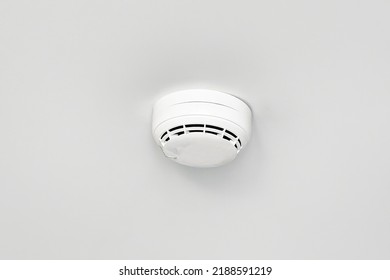 Smoke detector or fire alarm sensor on white ceiling.