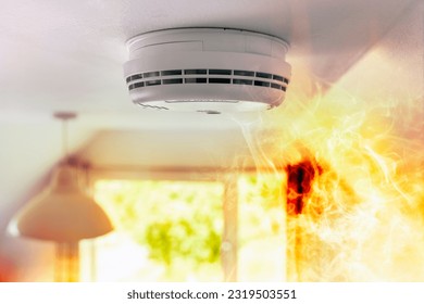 Smoke detector and interlinked fire alarm on ceiling in action background with copy space