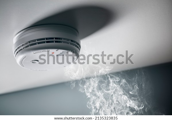 Smoke detector and interlinked fire alarm in action\
background with copy\
space