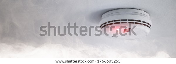 Smoke detector on the ceiling in case\
of fire alarm due to smoke as fire protection\
warning