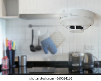 Smoke Detector On The Ceiling With Kitchen Background. Home Fire Safety.