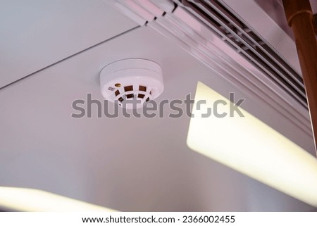 Smoke detector on ceiling in train, closeup of photo