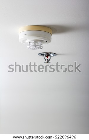smoke detector and pendent fire sprinkler on a ceiling