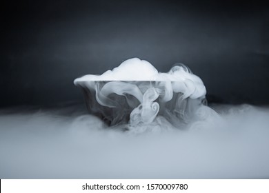 Smoke from dry ice in a bowl, black background - Powered by Shutterstock