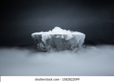 Smoke from dry ice in a bowl, black background - Powered by Shutterstock