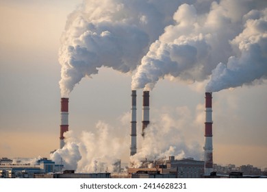 Smoke from factory pipe of heat station in the city in winter time. Fuel oil or natural gas-fired power plant. Air pollution. Chimneys, ecology, heating season concept.  - Powered by Shutterstock