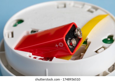 A Smoke And Fire Detector Showing The Battery Being Installed