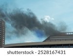 The smoke from the fire from the roof of the administrative building is thick and black. Horizontal photo