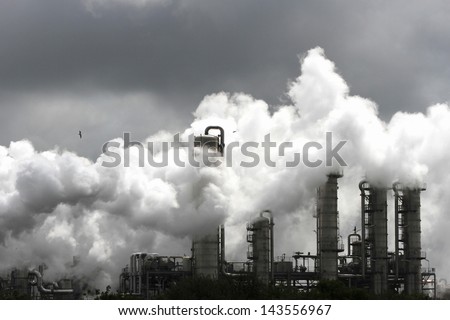 Smoke of heavy industry is highlighted by the sun. Shot in the Dutch industry area of the Europoort
