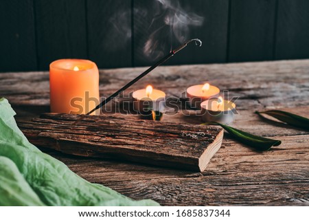 Smoke from incense stick and relaxing candles on rustic wood