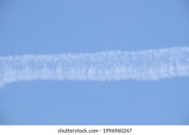 The Smoke Of A Jet Plane Against The Afternoon Sky.