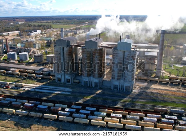 Smoke from pipes of cement plant. Сement Factory\
with smoke pipe. Air pollution. Chimney smokestack emission. Cement\
freight cars. Transport bulk materials on railroad. Tank cars at\
industrial plant. 