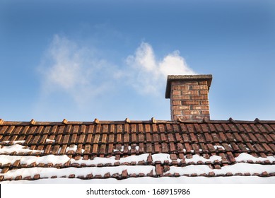 Smoke raising from a chimney in winter